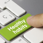 Photo: finger pressing healthy habits text on a keyboard
