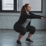 person in athletic clothing doing squat