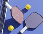 pickleball net with two pickleball paddles and balls