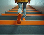 Person walking up steps with orange sneakers