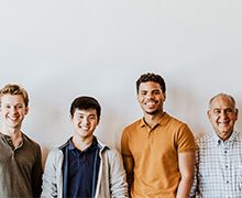 group of men standing together smiling