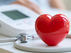 blood pressure cuff in background with bright red heart