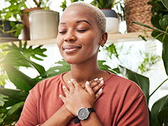 person sitting peacefully with hands crossed over heart