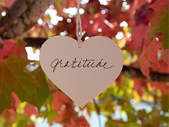 leaves in background with heart hanging with gratitude 